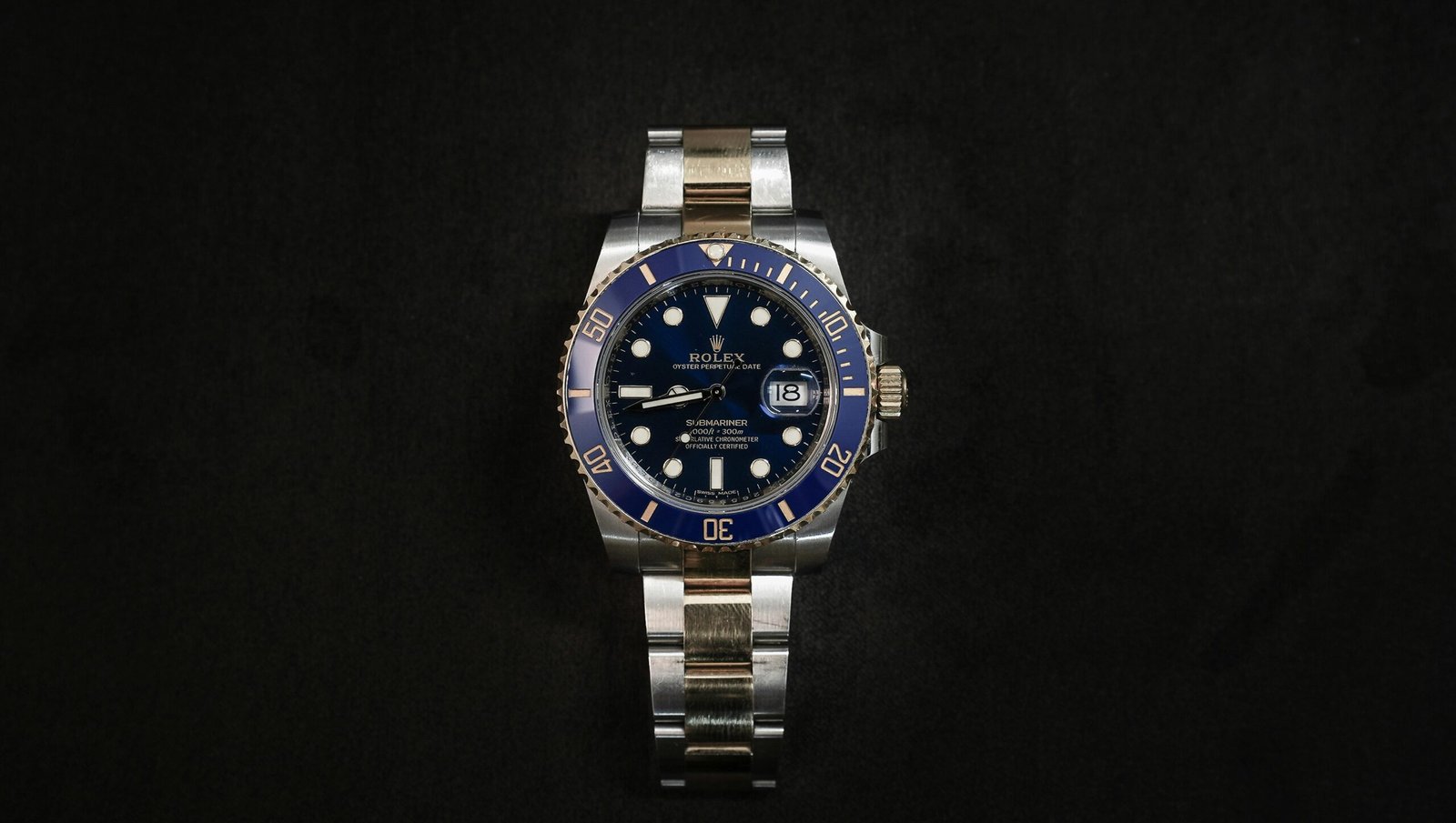 Close-up of a luxurious Rolex wristwatch on a black background.